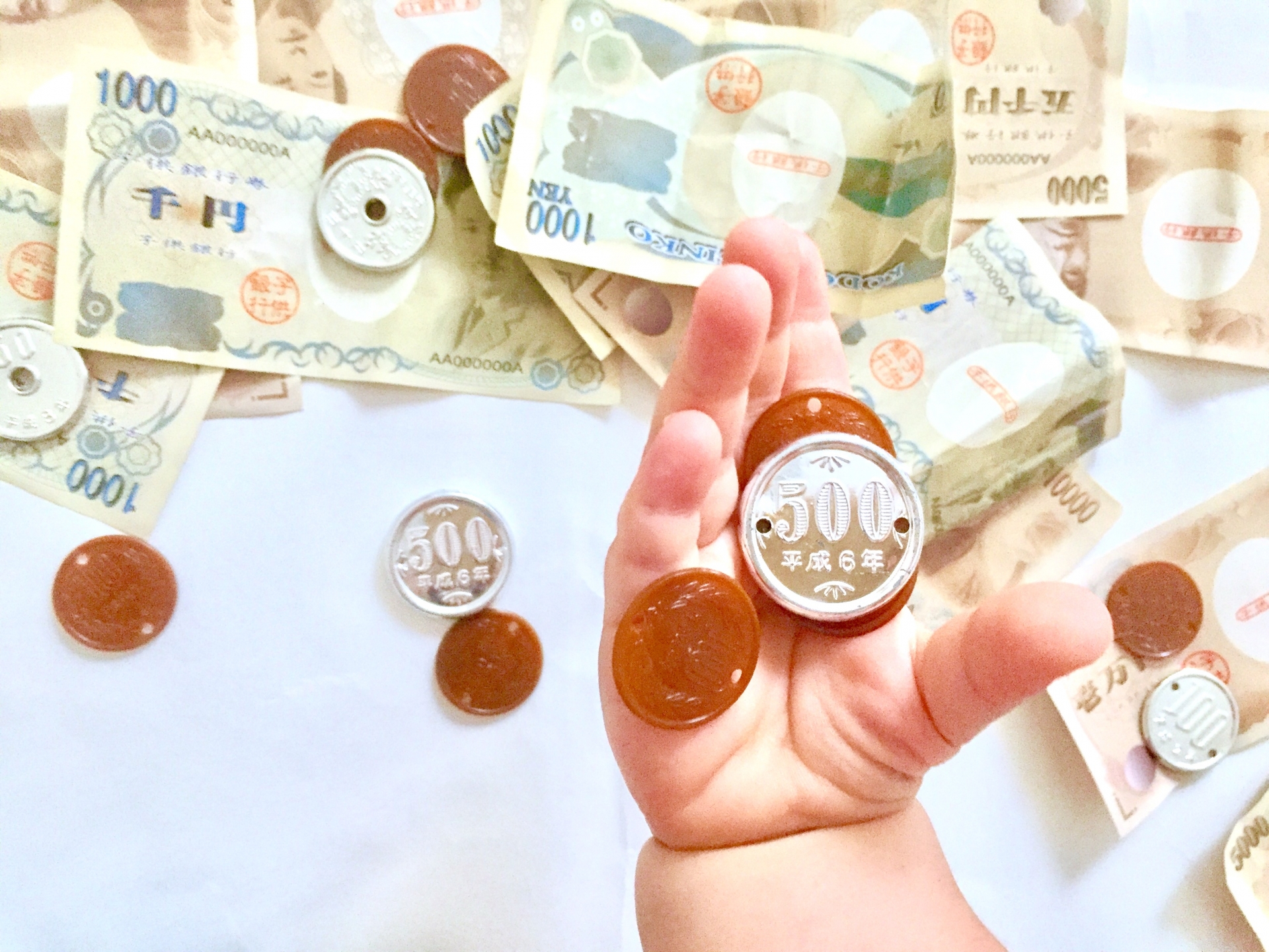 おもちゃのお金　子どもの手　募金